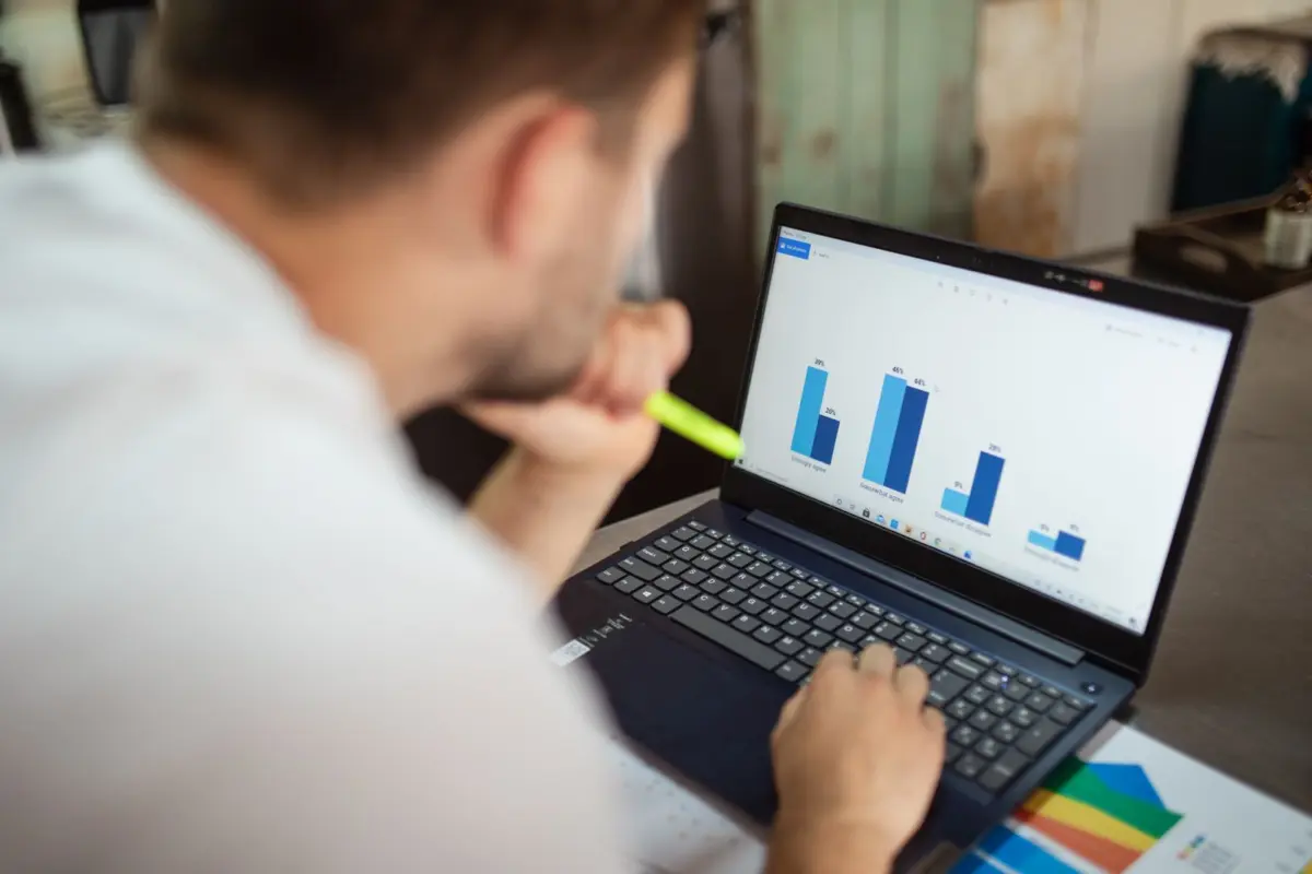 Business owner reviewing bar charts on a laptop to check whether SEO is working