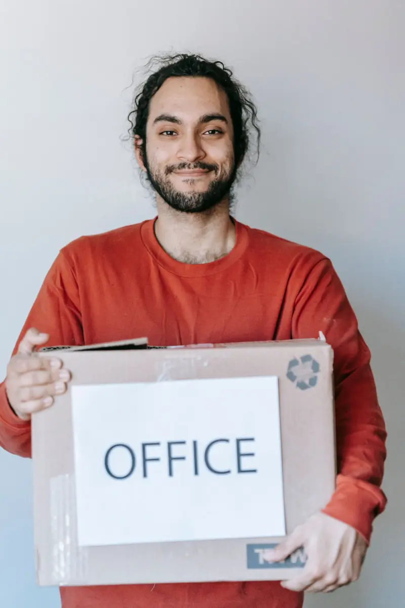Business owner carrying a box labelled office while moving to a new address
