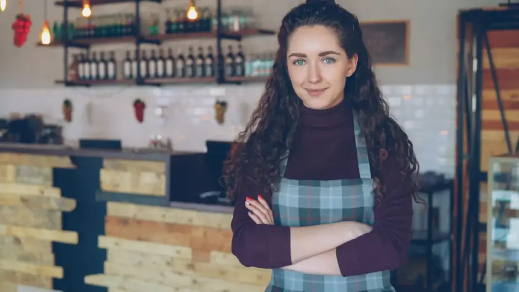 Café owner standing in her coffee shop wondering: does my business need a website?