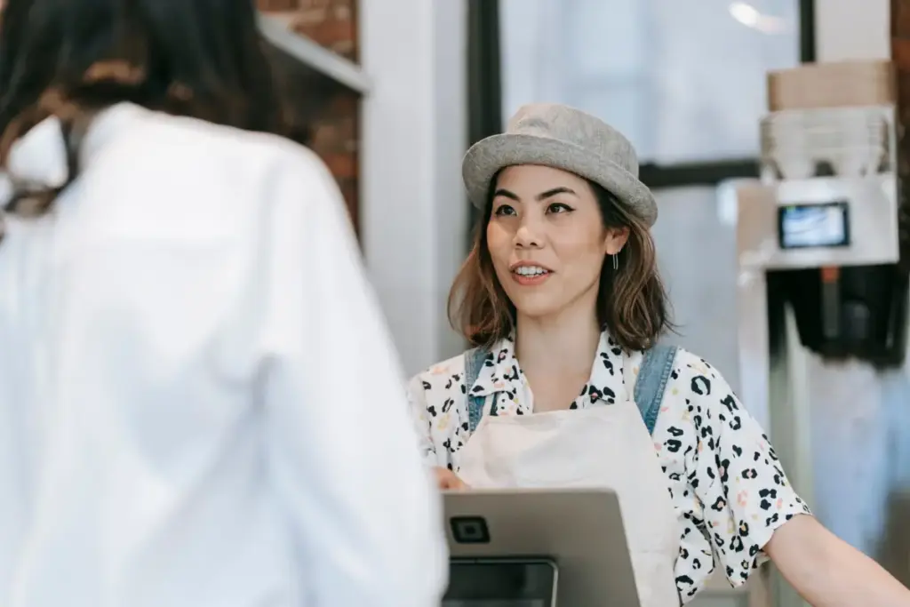 Cafe owner serving a happy customer, showing how to get more Google reviews