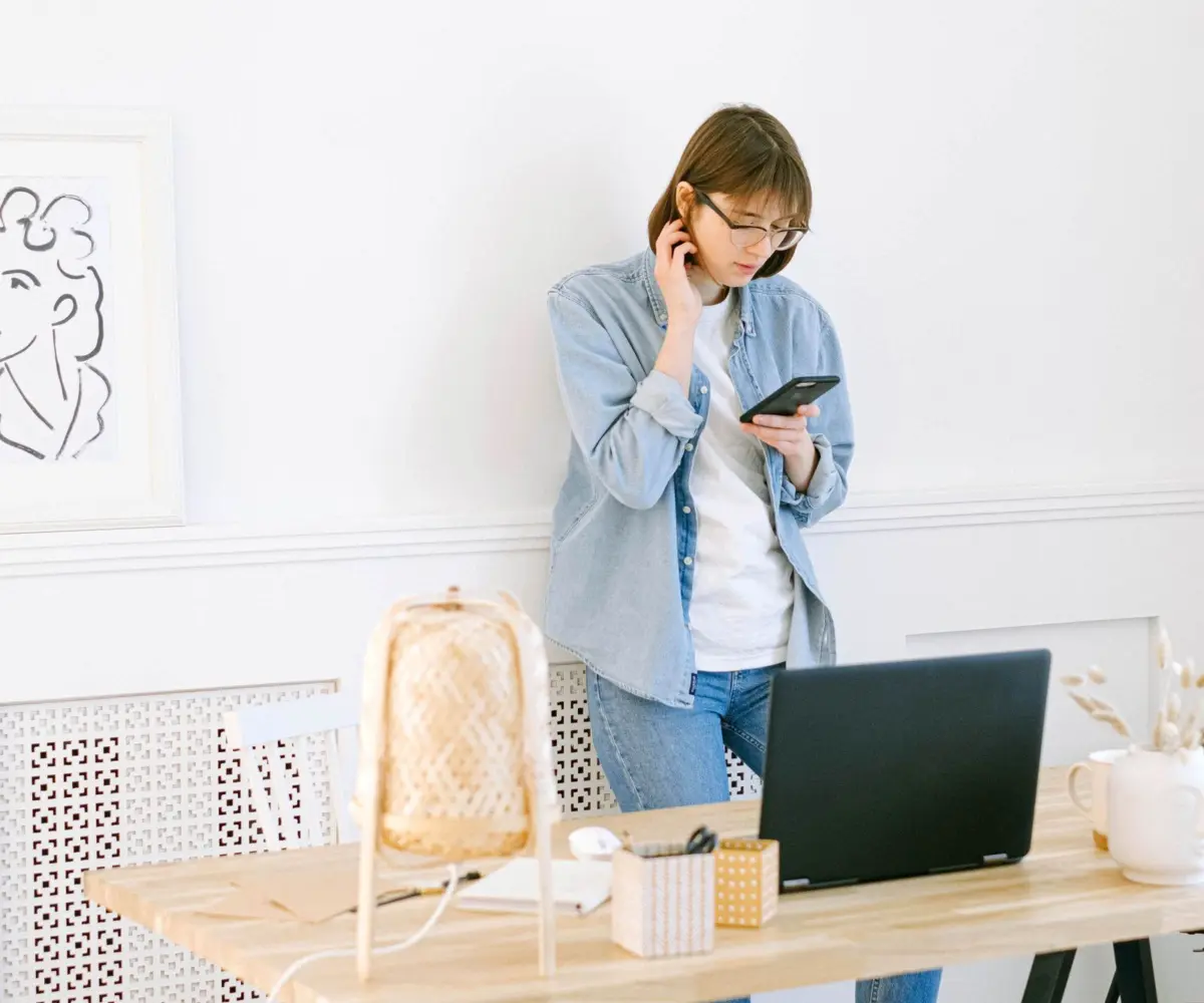 Small business owner on a phone call while planning her website on a laptop