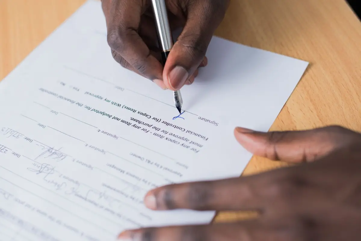 Business owner signing a web design contract that confirms who owns the domain and website